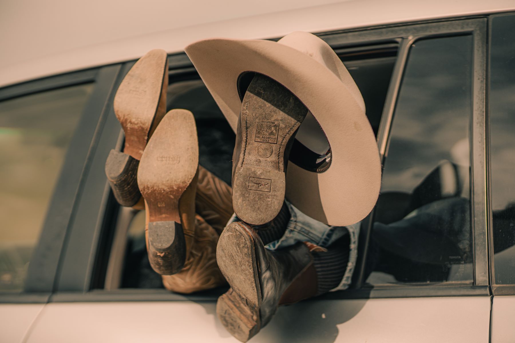 Two sets of farm boots and an akubra out the window